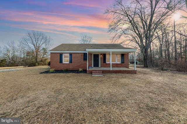 ranch-style home with a lawn and a porch