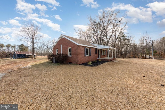 view of side of home featuring a yard and a porch