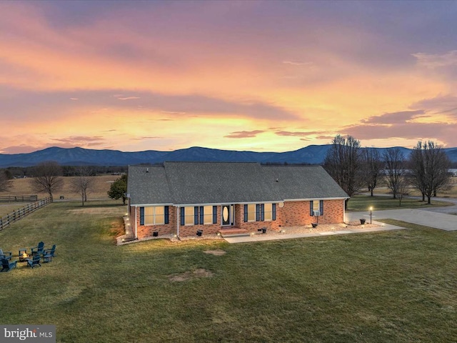 view of front facade featuring a mountain view and a lawn