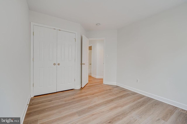 unfurnished bedroom with a closet and light wood-type flooring