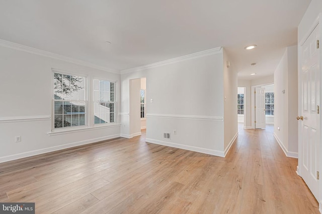 empty room with crown molding and light hardwood / wood-style flooring