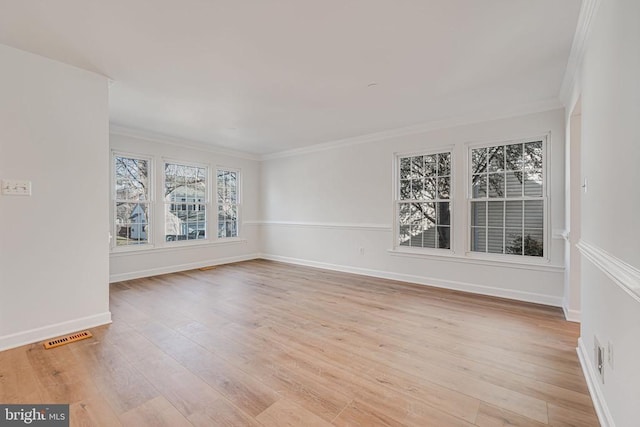 unfurnished room featuring ornamental molding and light wood-type flooring