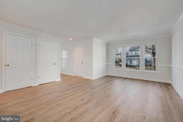 spare room featuring crown molding and light hardwood / wood-style flooring