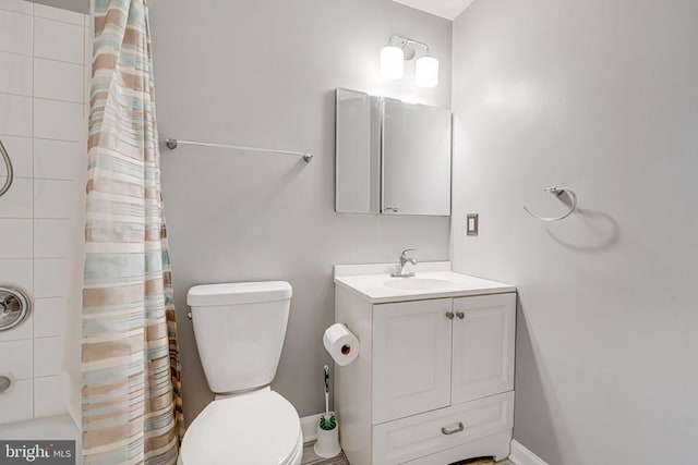 bathroom with vanity, curtained shower, and toilet