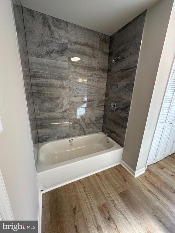 bathroom featuring hardwood / wood-style flooring and tiled shower / bath combo