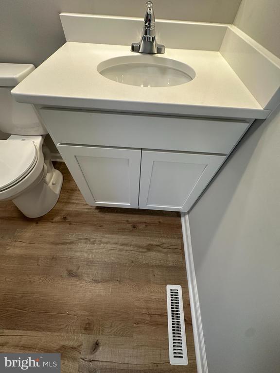 bathroom with vanity, hardwood / wood-style flooring, and toilet