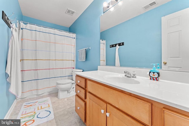 bathroom featuring vanity, tile patterned flooring, toilet, and walk in shower