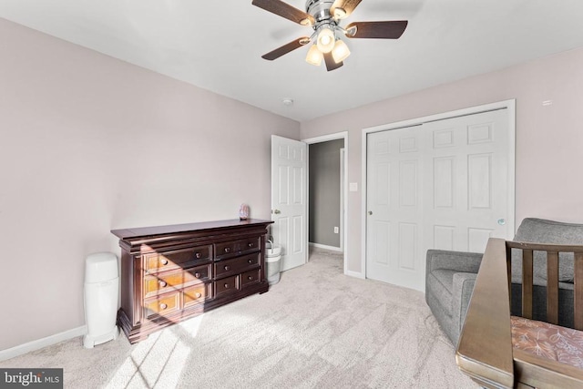 bedroom with light carpet, ceiling fan, and a closet