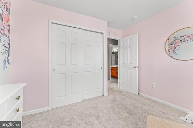 unfurnished bedroom featuring light colored carpet and a closet