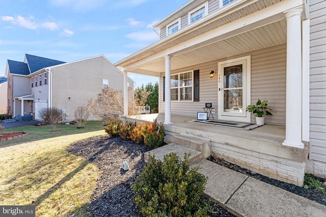 doorway to property featuring a porch and a yard