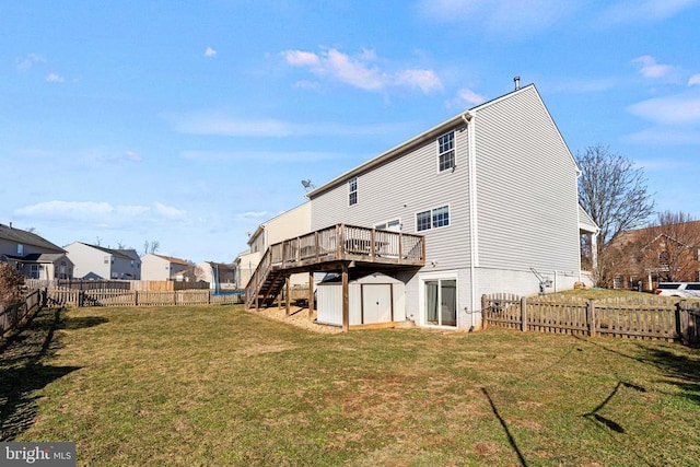 back of house featuring a wooden deck, a yard, and a storage shed