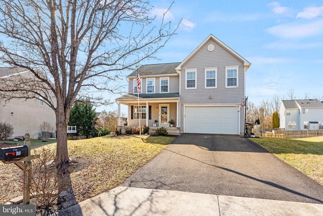 front facade featuring a garage, a front yard, and covered porch