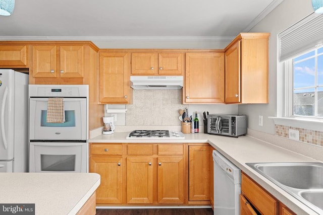 kitchen featuring tasteful backsplash, ornamental molding, sink, and white appliances