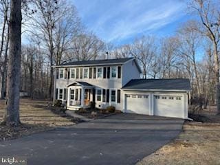 colonial-style house with a garage and driveway