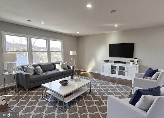 living room with recessed lighting, visible vents, and wood finished floors