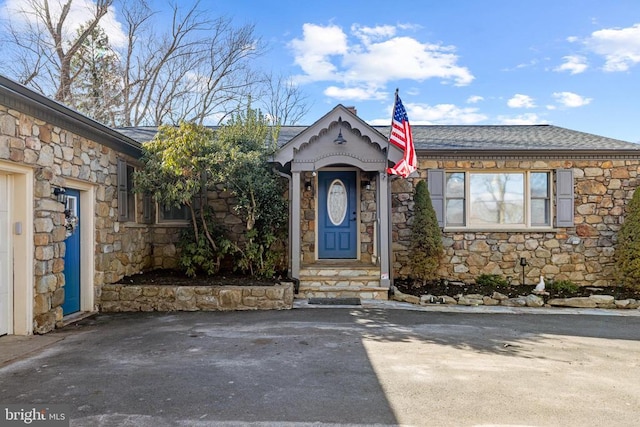 view of front of property with stone siding and driveway