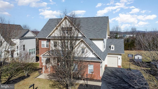 view of front of home with aphalt driveway, brick siding, and roof with shingles