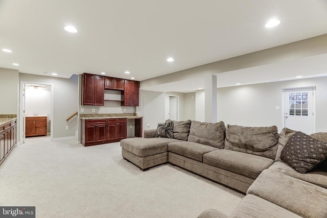 living area with recessed lighting, light colored carpet, indoor bar, and baseboards