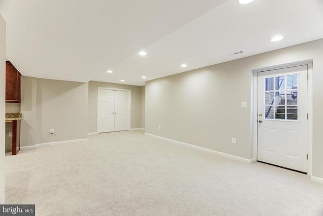 unfurnished living room with recessed lighting, visible vents, baseboards, and light colored carpet