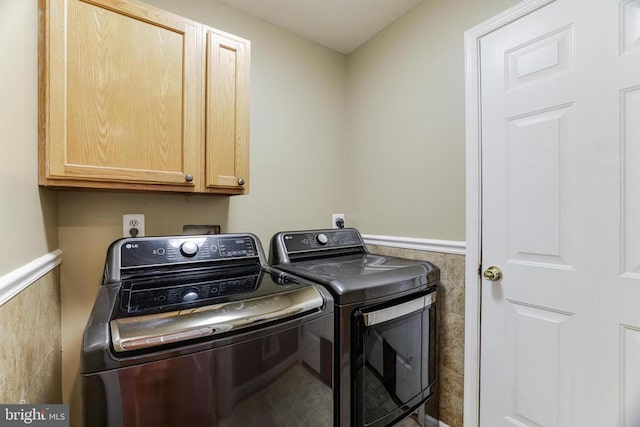 laundry area with washer and dryer, wainscoting, and cabinet space