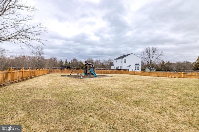 view of jungle gym featuring a lawn and a fenced backyard