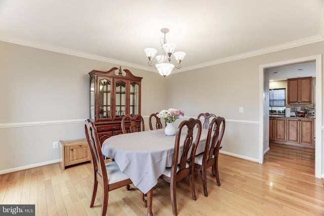 dining room with light wood-type flooring, baseboards, a chandelier, and crown molding