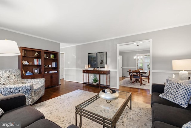 living area with crown molding, wood finished floors, baseboards, and a chandelier