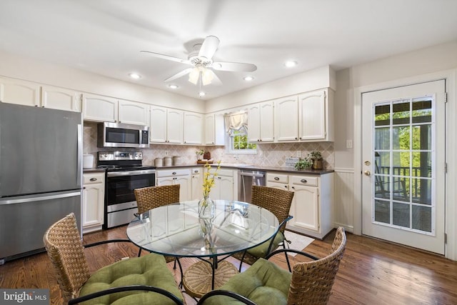 kitchen featuring dark countertops, appliances with stainless steel finishes, white cabinetry, and dark wood-style flooring