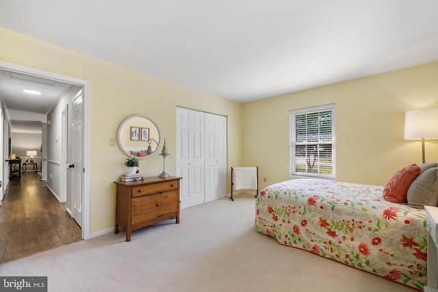 carpeted bedroom with a closet and baseboards