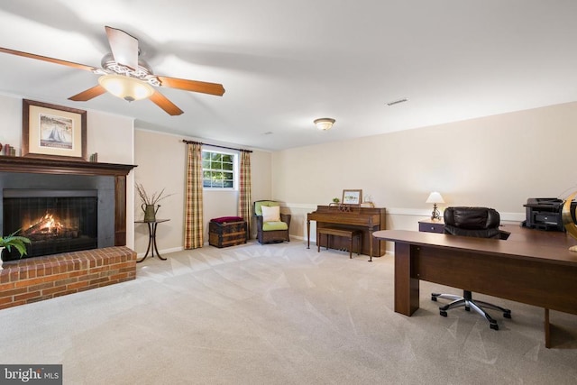 home office with carpet flooring, a brick fireplace, a ceiling fan, and baseboards