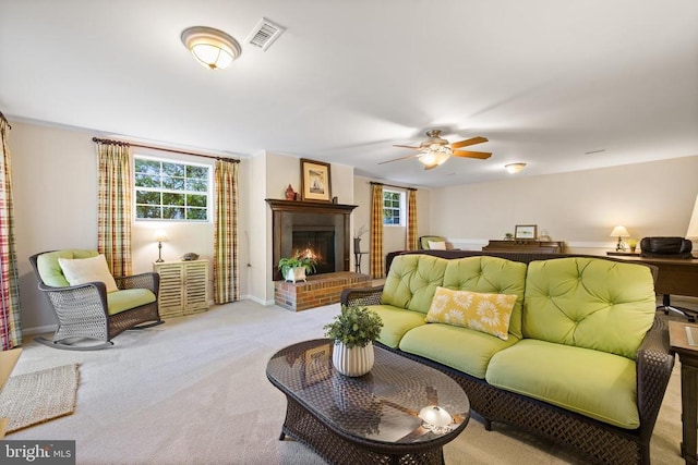 living area with a ceiling fan, visible vents, carpet floors, baseboards, and a fireplace