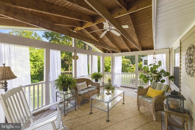 sunroom with lofted ceiling with beams and ceiling fan