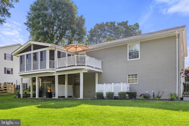 back of house with fence, a lawn, and a sunroom