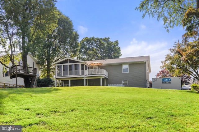 back of property with a lawn and a sunroom