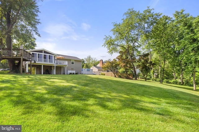 view of yard featuring a sunroom and a wooden deck