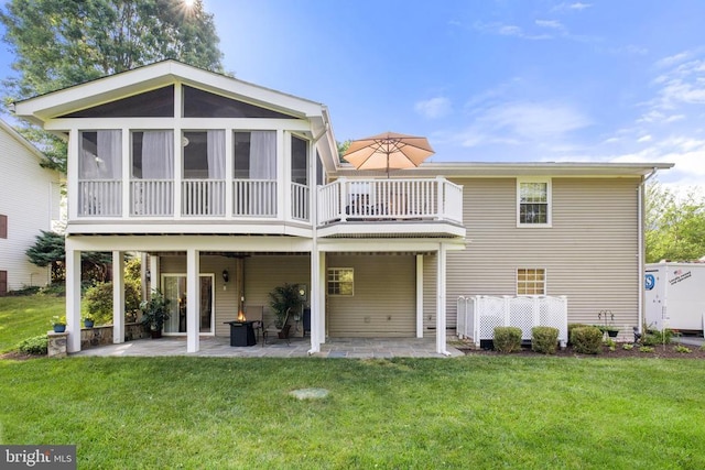 rear view of property featuring a patio, a lawn, and a sunroom