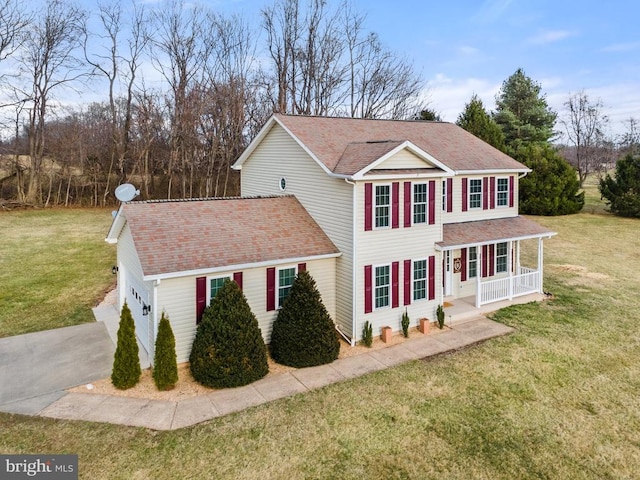 view of front of house with a porch, concrete driveway, and a front yard