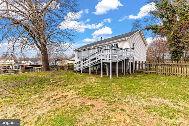 back of house featuring stairway, a fenced backyard, a lawn, and a deck