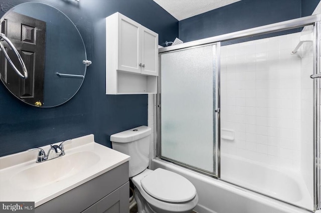 full bath with vanity, toilet, bath / shower combo with glass door, and a textured ceiling