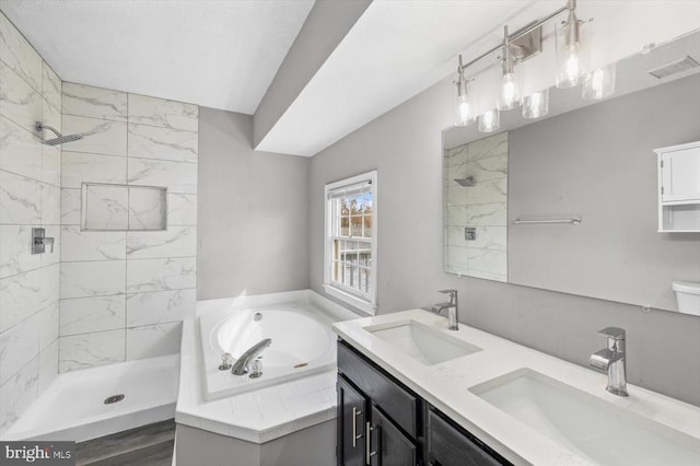 full bathroom with tiled shower, visible vents, and a sink