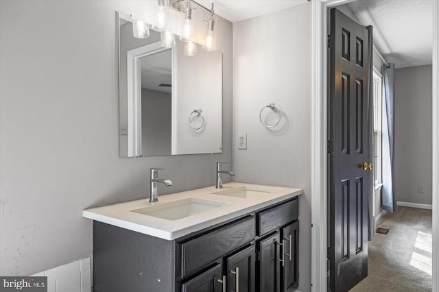 bathroom with a sink, baseboards, and double vanity