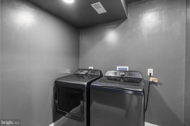 clothes washing area featuring laundry area, separate washer and dryer, and visible vents