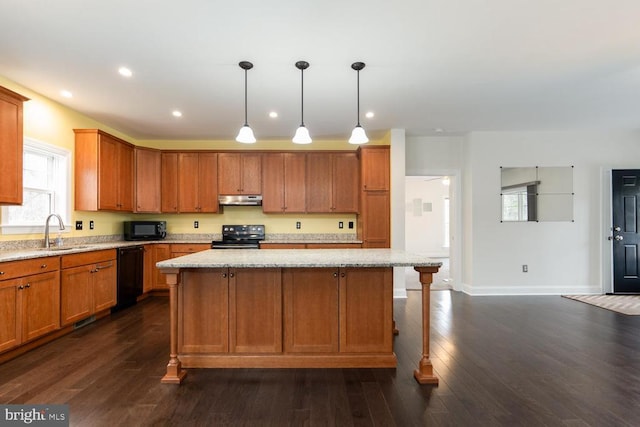 kitchen with a sink, a kitchen island, under cabinet range hood, black appliances, and dark wood-style flooring