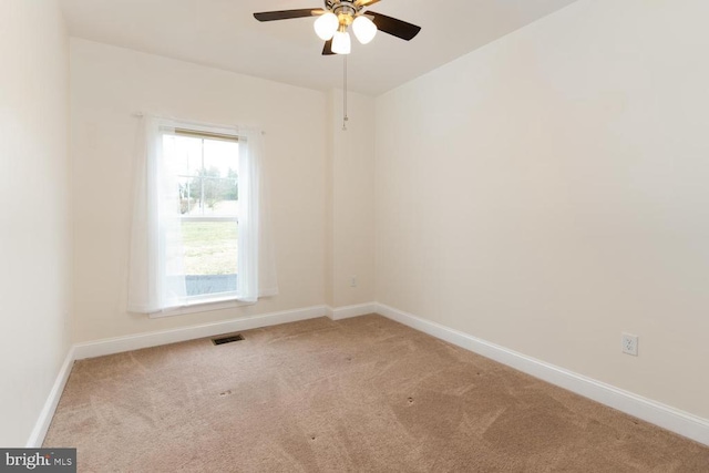 spare room featuring visible vents, carpet floors, baseboards, and ceiling fan