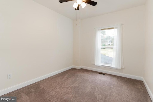 empty room featuring visible vents, carpet flooring, a ceiling fan, and baseboards