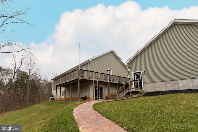 rear view of property featuring a yard and a wooden deck