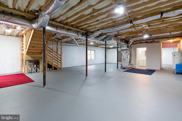 basement featuring stairs and water heater