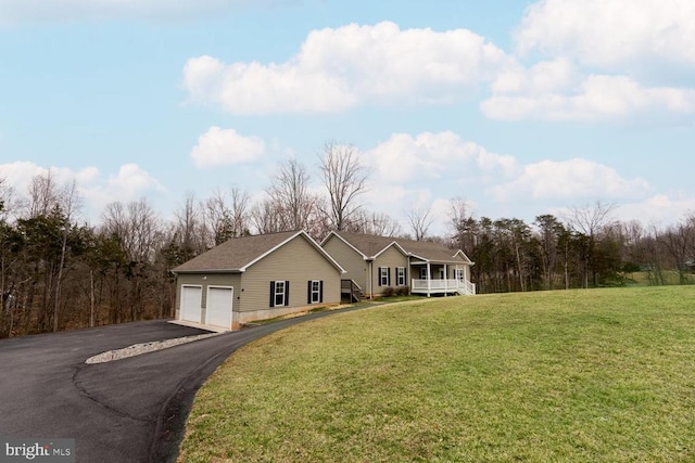 view of front of home featuring a front yard, an attached garage, and driveway