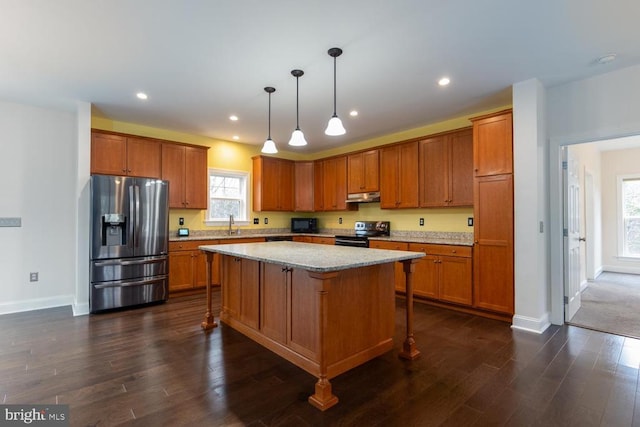 kitchen with black electric range, brown cabinetry, under cabinet range hood, and stainless steel fridge with ice dispenser