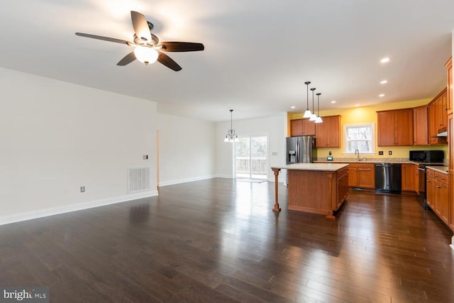 kitchen with dishwashing machine, visible vents, dark wood-type flooring, black microwave, and stainless steel fridge